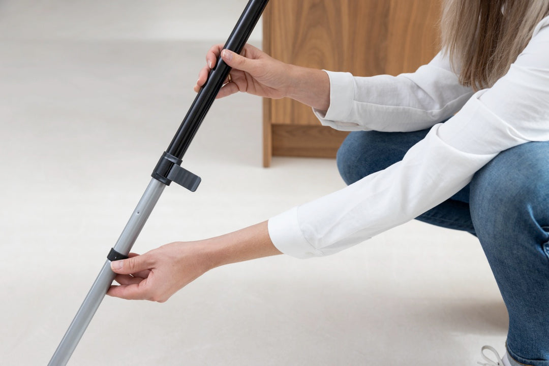 A person adjusts the telescopic handle, preparing for cleaning