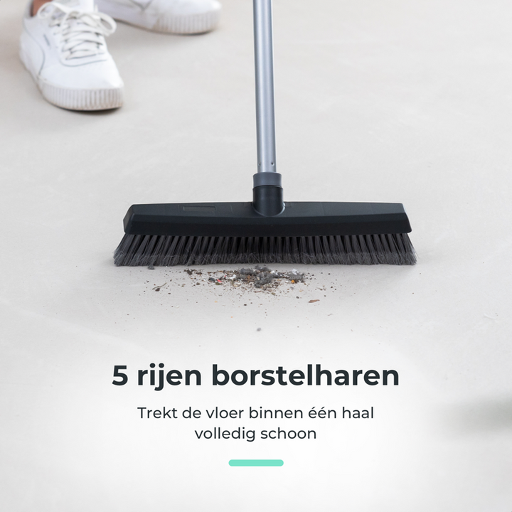 The cleanly telescopic broom sweeping dirt, showing the effectiveness of its five rows of bristles