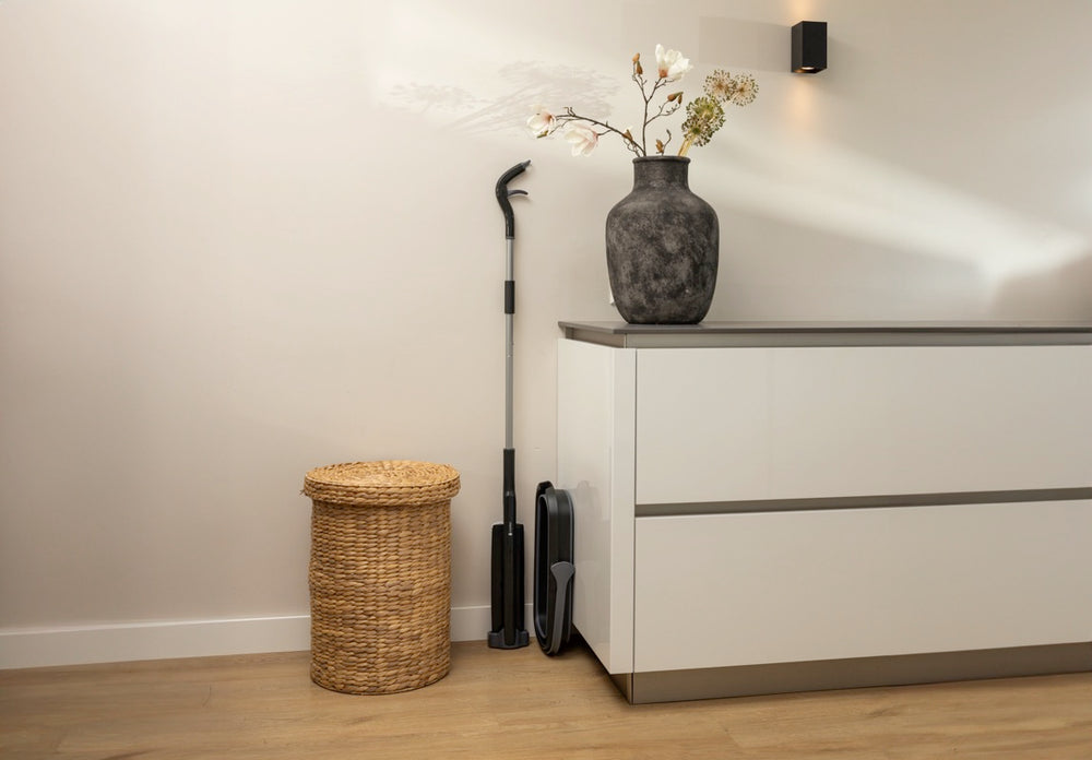 Cleaning set with mop and bucket stored next to a cabinet